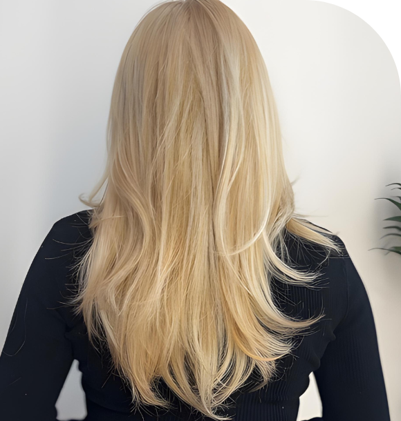 A stylist applying bleach to a client's hair