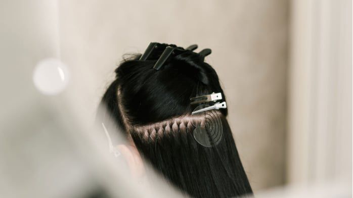 A client with long, dark hair extensions